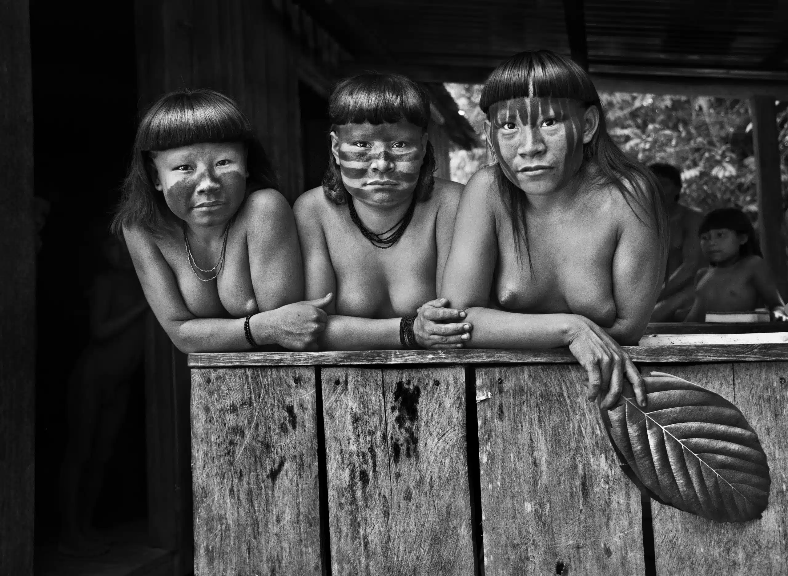 As primas Hahani, Tiniru e Ugunja no posto de saúde da SESAI, próximo ao igarapé Pretão (Jukihi). Ugunja morreu alguns meses após esta fotografia. Os Suruwahá têm alto índice de mortes, provocadas pela ingestão voluntária de timbó (derris ellíptica), substância altamente tóxica, usada para a pesca e a caça. Terra Indígena Suruwahá. Estado do Amazonas, 2017. Sebastião Salgado